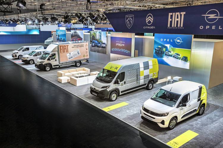 Moderne Transporter der Marken Fiat, Citroën und Opel auf einer Fachmesse für Gebäudetechnik, beleuchtet von hellen Scheinwerfern; Ideal für SHK-Betriebe und TGA-Planer zur effizienten Material- und Werkzeuglogistik.