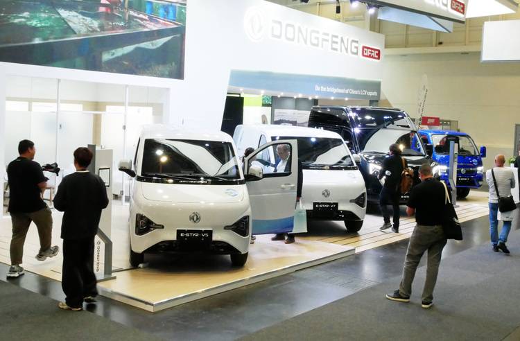ALT-Text: „Messestand präsentiert Dongfeng Elektrofahrzeuge für den Einsatz in nachhaltiger Gebäudetechnik, umgeben von Fachleuten und Entscheidern aus der Branche.