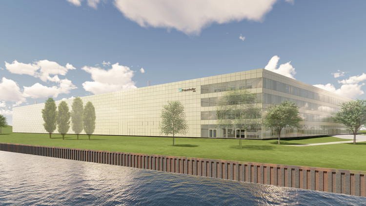 Alt-Text: „Modernes Bürogebäude mit energieeffizienter Glasfassade, umgeben von Bäumen und nahe einem Gewässer als Zeichen nachhaltiger Bauweise im Kontext der Gebäudetechnik.“.