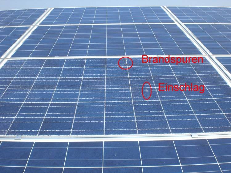 Alt-Text: Nahaufnahme von Solarmodulen mit Markierungen, die Brandspuren und Oberflächenschäden aufzeigen, relevant für die Bewertung von Solaranlagen in Bezug auf Effizienz und Wartungsbedarf in der Gebäudetechnikbranche.