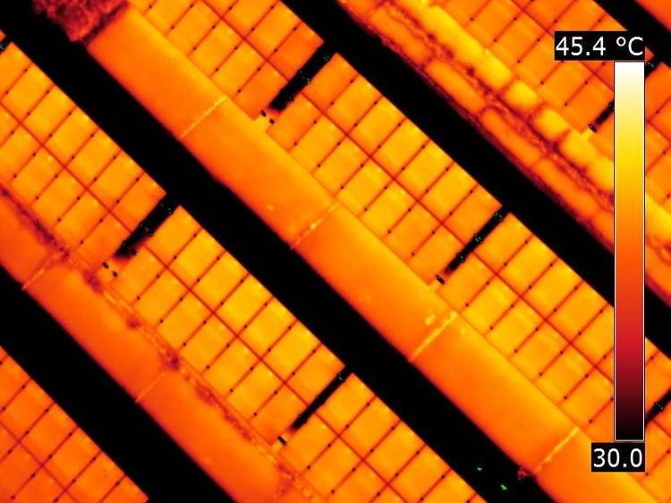 Alt-Text: „Thermografie-Aufnahme von Solarpanels auf einem Gewerbedach, die Temperaturunterschiede zwischen 30,0°C und 45,4°C zur Beurteilung der Energieeffizienz und Funktionsfähigkeit zeigt.