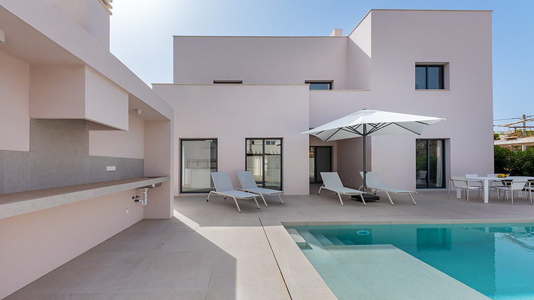 ALT-Text: "Energieeffizientes Einfamilienhaus mit moderner Heizungs- und Klimatechnik, ausgestattet mit einer nachhaltigen Solaranlage und energieeffizienten Fensterlösungen, sichtbar sind Poolbereich, Sonnenliegen und ein Terrassentisch unter einem Sonnenschirm an einem sonnigen Tag. Ideales Beispiel für moderne Gebäudetechnik.