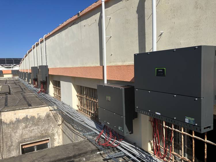 ALT-Text: „Solarwechselrichter auf einem Gebäude installiert, umgeben von sauberer Verkabelung, mit Fokus auf nachhaltige Energieversorgung und Optimierung der Energieeffizienz in modernen Gebäudetechniken.