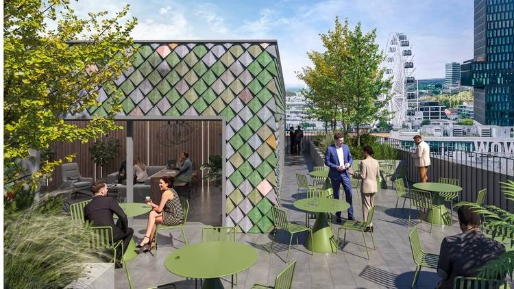 Fachleute aus der Gebäudetechnik diskutieren auf einer Dachterrasse mit grünen Tischen und Stühlen über nachhaltige Energieeffizienzlösungen, umgeben von urbaner Architektur im Hintergrund.