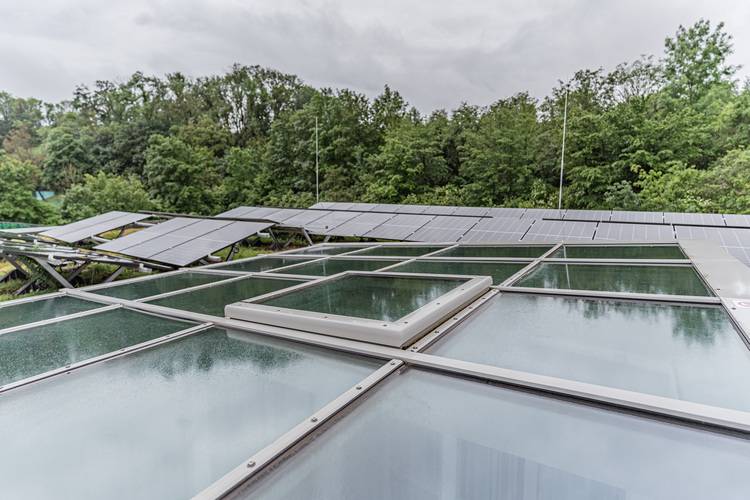 ALT-Text: „Moderne Solarthermie- und Photovoltaikanlage auf einem Gebäudedach, integriert mit Tageslichtsystemen zur Optimierung von Energieeffizienz, umgeben von nachhaltiger Architektur im Einklang mit grünen Technologien.“.