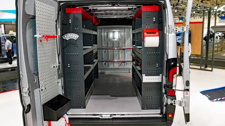 ALT-Text: „Innenansicht eines grauen Servicefahrzeugs, ausgestattet mit maßgeschneiderten Regalen, Werkzeughalterungen und effizient organisiertem Stauraum für Gebäudetechnik-Fachkräfte.