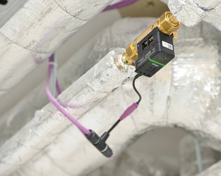 Schematische Darstellung eines modernen, energieeffizienten Sensorsystems, das an isolierten Rohrleitungen in einer Gebäudezwischendecke installiert ist, um die Heizungs- und Kühlleistung zu optimieren.