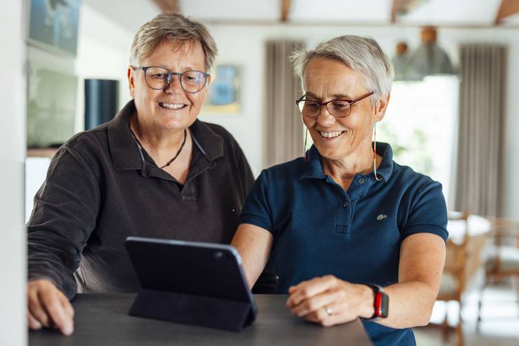 Zwei Fachleute aus der Gebäudetechnikbranche betrachten gemeinsam technische Pläne auf einem Tablet in einem gut beleuchteten Raum, um Lösungen für energieeffiziente Heizungs- und Klimatechnik zu besprechen.
