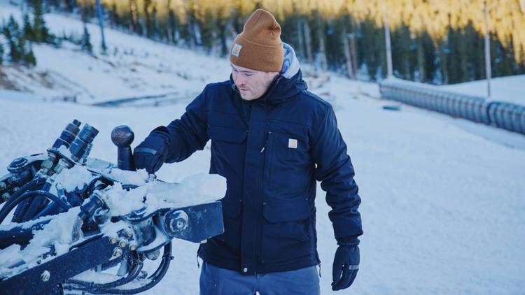 Techniker in Winterkleidung justieren eine Heizungsanlage im verschneiten Außeneinsatz, um die Energieeffizienz zu optimieren.