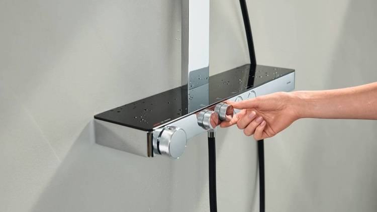 Alt-Text: „Fachkraft justiert Regler an einem modernen Chrom-Duschpaneel zur Optimierung des Wasserdrucks in einer barrierefreien Sanitäreinrichtung.