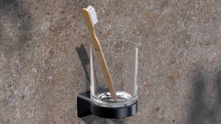 Alt-Text: „Nachhaltige Holz-Zahnbürste in einem Glasbehälter, montiert an einer wandintegrierten Sanitärlösung aus Steinoptik, geeignet für moderne energieeffiziente Badezimmerkonzepte.