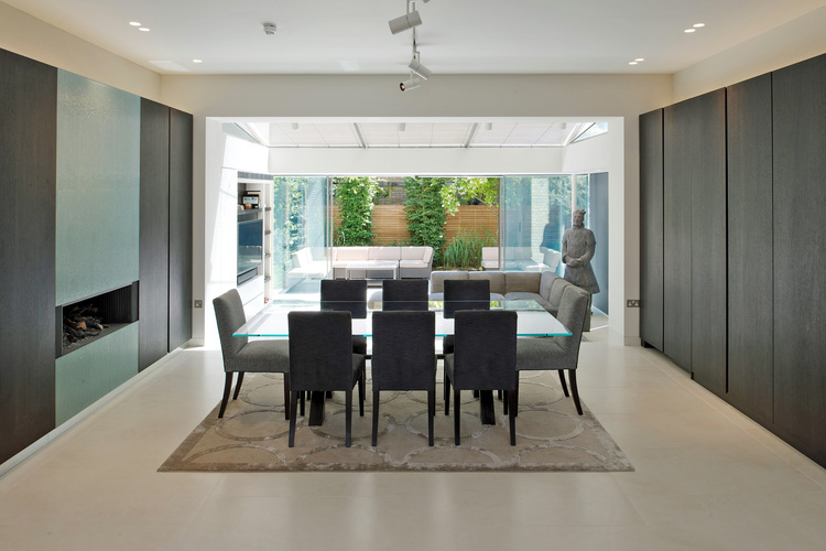 Alt-Text: „Moderner Besprechungsraum mit großem Konferenztisch und grauen Stühlen, eröffnet den Blick auf eine mit nachhaltigen Materialien gestaltete Terrasse und energieeffiziente Nutzung von Tageslicht.“.