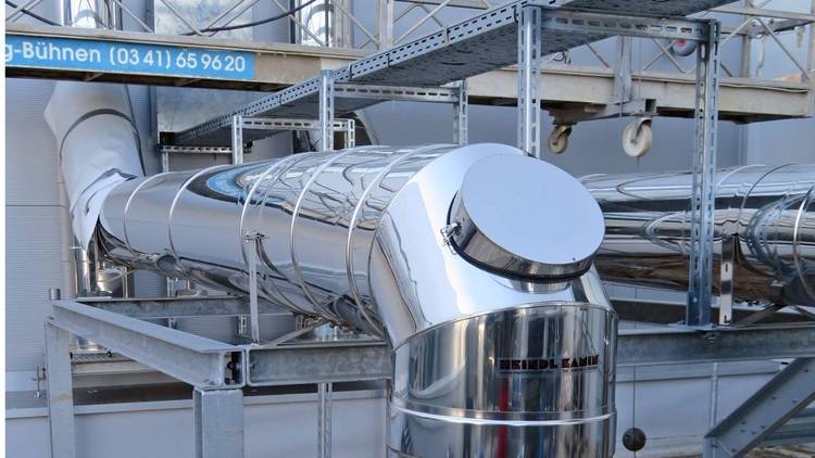 Alt-Text: „Moderne Industrieleitungen und Strukturplattformen in einer Außenumgebung, die effiziente Verteilung und Regelung von Heizungs- und Klimasystemen in großen Gebäudekomplexen veranschaulichen.