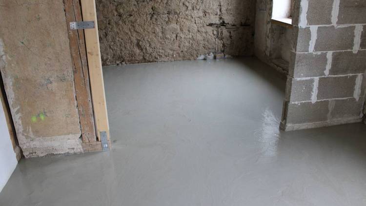 ALT-Text: „Frisch gegossener Betonboden in einem Rohbau, verdeutlicht die Notwendigkeit energieeffizienter Gebäudehüllenkonzepte und nachhaltiger Raumgestaltungstechniken im Bauwesen.