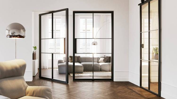 Alt-Text: „Moderner Wohnraum mit großer Fensterfront, energiesparendem LED-Beleuchtungssystem und nachhaltiger Fußbodenheizung unter einem dunklen Fischgrät-Holzboden für optimale Energieeffizienz in der Gebäudetechnik.