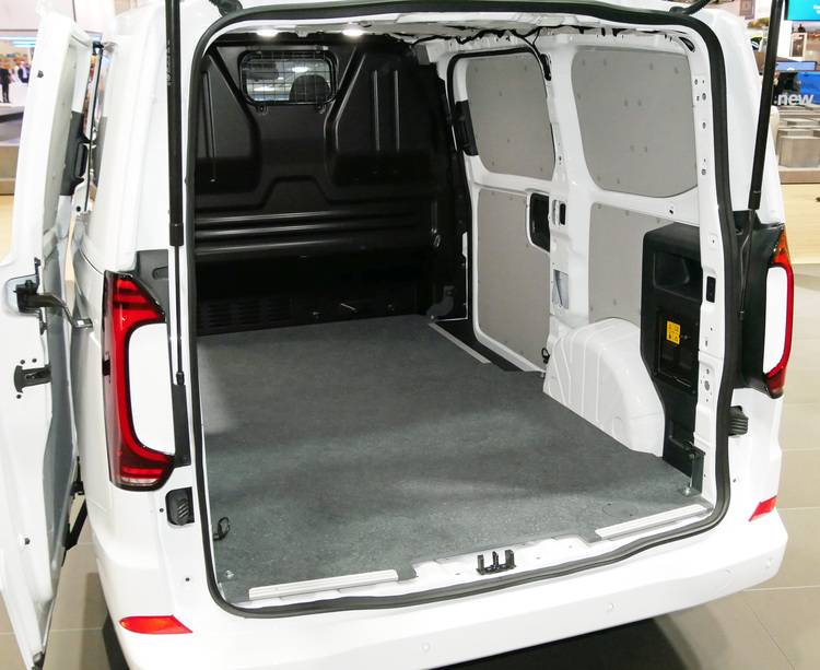 Alt-Text: „Innenraum eines leeren weißen Servicefahrzeugs mit geöffneten Hecktüren, ausgestattet für den Transport von Sanitär- und Heizungsinstallationsteilen.