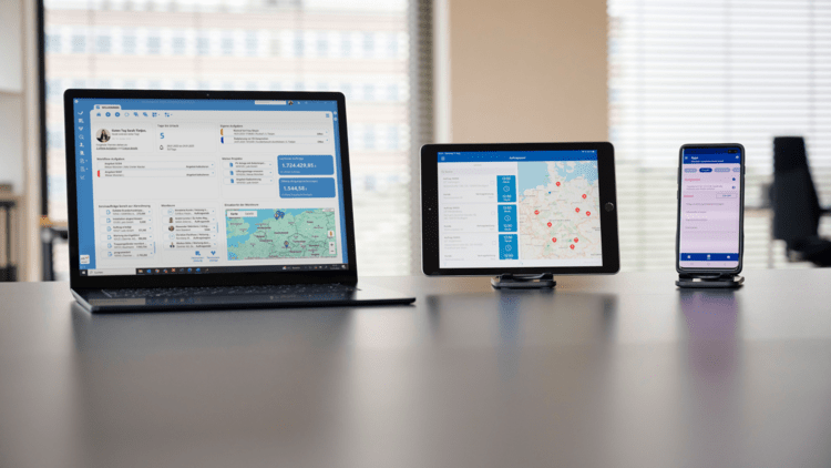 ALT-Text: „Laptop, Tablet und Smartphone auf einem Tisch zeigen lizenzierte Gebäudemanagement-Software zur Steuerung von Heizungs-, Lüftungs- und Klimasystemen.