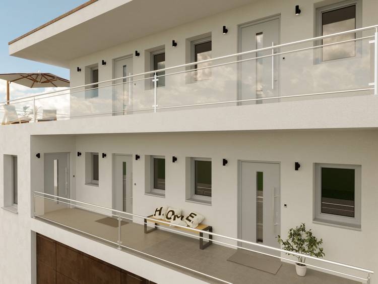 Mehrfamilienhaus mit energieeffizienter Gebäudefassade, ausgestattet mit modernen Balkonen und Glashäusern, Symbol für nachhaltige Gebäudeplanung in der Gebäudetechnikbranche.