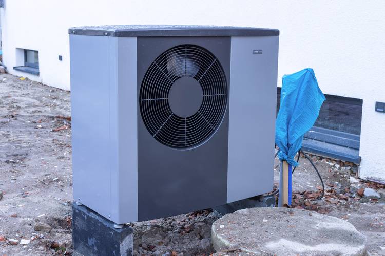 ALT-Text: „Effiziente Wärmepumpeneinheit für nachhaltige Gebäudeversorgung, auf Betonfundament montiert, ideal für Umstellung auf erneuerbare Außenenergien in der modernen Gebäudetechnik.“.