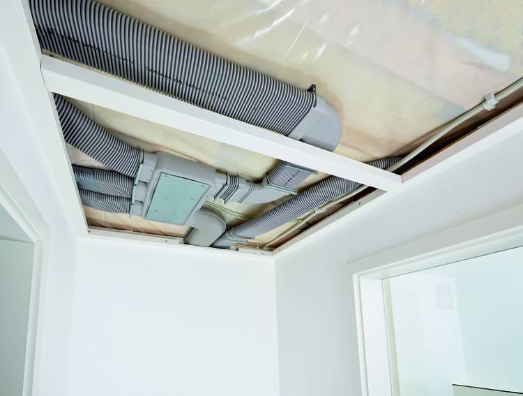 „Decke in einem renovierten Raum mit sichtbaren HVAC-Kanälen und elektrischen Leitungen, die die Integration moderner Gebäudetechnik und nachhaltiger Energieeffizienzlösungen veranschaulichen.