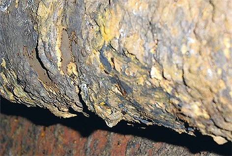 Nahaufnahme einer stark korrodierten Rohrleitung mit abgeblättertem Material, veranschaulicht die Notwendigkeit effizienter Instandhaltungsmaßnahmen in der Gebäudetechnik.