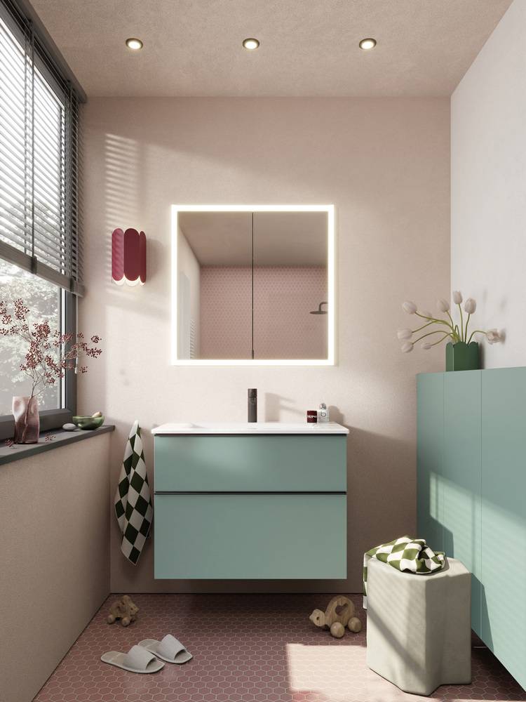 Moderner, barrierefreier Sanitärraum mit beleuchtetem Spiegel, türkisfarbenem Waschtischunterschrank und rosa Akzenten; im Fokus auf energieeffizienten Technologien und nachhaltigen Materialien.