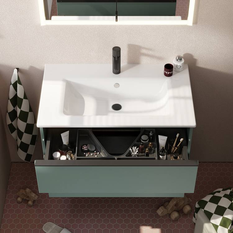 Sicher, hier ist ein optimierter ALT-Text für das Bild, der auf die Zielgruppe und den Kontext von haustec.de zugeschnitten ist: „Moderne Waschtischanlage mit offener Schublade, die Hygieneprodukte für barrierefreie Sanitärlösungen zeigt; Fokus auf energieeffizientem Design und hexagonalen Fliesen als Beispiel für innovative Gestaltung in der Gebäudetechnik.“.