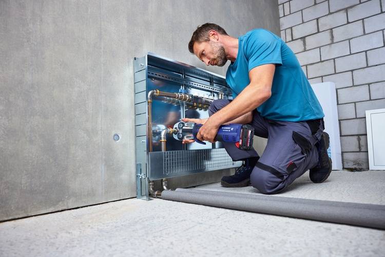 Hier ist ein optimierter ALT-Text, zugeschnitten auf die Zielgruppe und den fachlichen Kontext von haustec.de: Optimierter ALT-Text: „Fachhandwerker bei der Montage und Wartung freiliegender Rohrleitungen an einer Betonwand mit einem Akku-Bohrschrauber – Anwendung moderner Gebäudetechnik im Bestand.“ Begründung: - Die Beschreibung adressiert die Zielgruppe direkt (Fachhandwerker/Montage/Wartung). - Der verwendete Begriff „freiliegende Rohrleitungen“ ist in der Gebäudetechnik geläufig. - Es wird das Werkzeug („Akku-Bohrschrauber“) präzise benannt. - Es wird deutlich gemacht, dass es sich um eine typische Tätigkeit in der Gebäudetechnik handelt. - Die Formulierung „im Bestand“ unterstützt den Bezug zur Sanierung und Modernisierung von Gebäuden. Melde dich gerne für weitere Bilder oder Texte!.