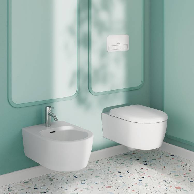 Alttext: "Modernes Badezimmer mit wandhängendem Bidet und Toilette, vor einer mintgrünen Wand und Terrazzo-Boden. Schwerpunkt auf effizienter Wassernutzung und barrierefreier Installation für Fachhandwerker im Bereich Sanitärtechnik.