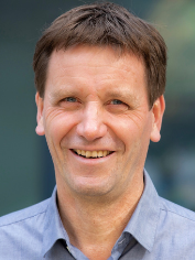 Gern! Hier ist ein präziser, themenrelevanter ALT-Text für das beschriebene Bild, zugeschnitten auf die Zielgruppe und den Kontext von haustec.de: Optimierter ALT-Text: „Fachplaner Gebäudetechnik mit kurzem braunen Haar im hellblauen Hemd steht vor moderner Büroimmobilie – Symbolbild für Entscheider in der Sanitär-, Heizungs- und Klimatechnik-Branche“ Gerne passe ich Textlänge und Details weiter an, fällt Sie mehr über den Zusammenhang des Artikels wissen (z. B. Branchenevent, Porträt eines Experten oder allgemeines TGA-Thema).