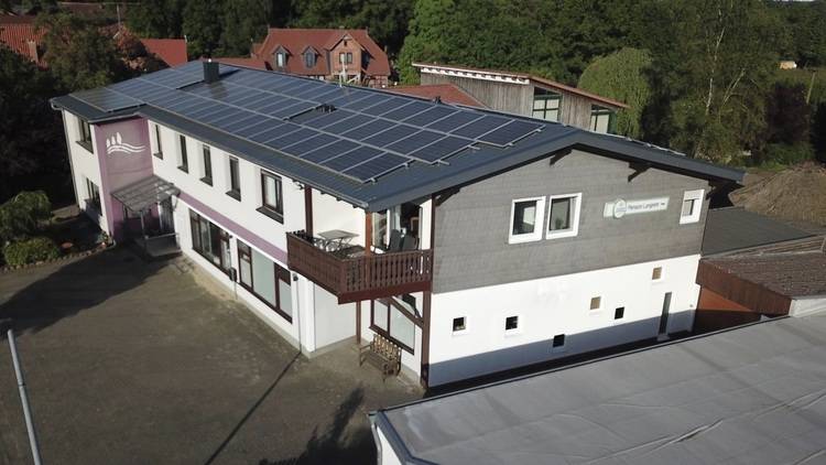 Gerne! Hier ist ein optimierter und themenrelevanter Alt-Text für das beschriebene Bild auf haustec.de: Barrierefreier, präziser ALT-Text: „Modernes Mehrfamilienhaus mit großflächiger Photovoltaikanlage auf dem Dach; nachhaltige Energieversorgung im Wohnquartier, umgeben von Grünflächen und benachbarten Gebäuden.“ Begründung: Dieser Text beschreibt gezielt den Gebäudetyp (Mehrfamilienhaus), die funktionale Technik (Photovoltaikanlage zur nachhaltigen Energieversorgung) und den städtebaulichen Kontext – exakt relevant für Leser aus der Gebäudetechnikbranche.