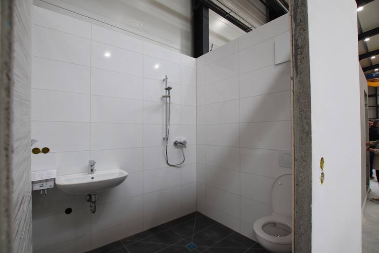 Gerne! Hier ein optimierter, themenrelevanter und für die Zielgruppe passender ALT-Text für das Bild: Barrierefreies Bad mit wandhängendem Waschtisch, rollstuhlgerechter Dusche ohne Schwelle und höhenangepasster WC-Anlage; weiße Fliesen an den Wänden, grauer rutschfester Bodenbelag - Beispiel moderner Sanitärplanung in der Gebäudetechnik. Möchtest du noch mehr Varianten oder auf bestimmte Aspekte (z. B. Armaturen, Haltegriffe, technische Detaillösungen) eingehen?.