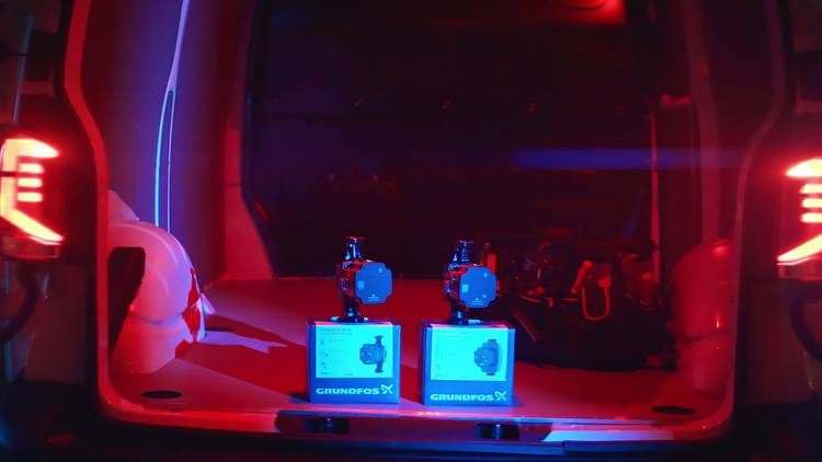 Optimierter ALT-Text: Zwei originalverpackte Grundfos-Heizungspumpen werden im Laderaum eines Transporters transportiert, ausgeleuchtet von rotem und blauem Licht - symbolisch für den professionellen Einsatz von moderner Pumpentechnik im SHK-Fachhandwerk und der Gebäudetechnik.