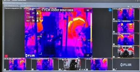 Optimierter ALT-Text: "Wärmebildkamera-Display zeigt Temperaturverteilung in einem Technikraum; auf dem Computerbildschirm werden Wärmebrücken und Energieverluste an Gebäudeelementen für die Analyse der Energieeffizienz sichtbar.