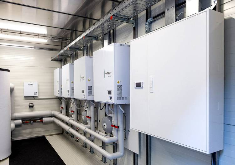 ALT-Text-Vorschlag (optimiert für haustec.de und die genannte Zielgruppe): "Reihe moderner, weißer Heizungs- und Lüftungsschaltanlagen mit angeschlossenen Rohrleitungen in einem Technikraum - typische Installation für Gebäudetechnik-Projekte im Bereich Heizung, Lüftung und Automation." Begründung: Der Text benennt präzise die abgebildeten Komponenten (Schaltanlagen/Steuerungen, Rohrleitungen), den Anwendungsort (Technikraum), verweist auf den Gebäudetechnik-Kontext und bedient durch die Verwendung branchenspezifischer Begriffe gezielt Entscheider, TGA-Fachleute und Ingenieure.