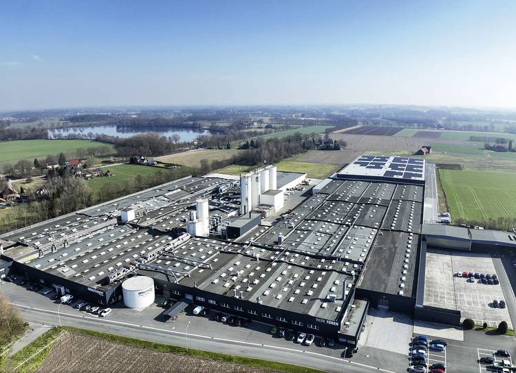 Luftaufnahme eines modernen Industriegebäudes für Gebäudetechnik, umgeben von Grünflächen - Fokus auf Energieeffizienz und nachhaltige Bauweise.