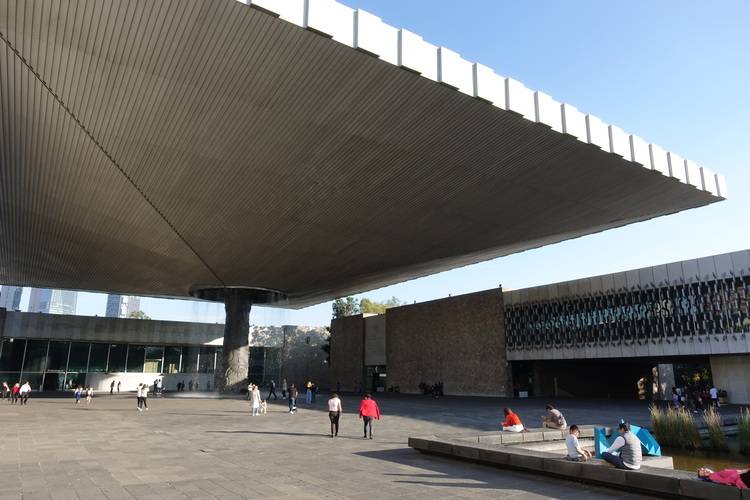 Gerne. Da der bisherige ALT-Text wenig Bezug zur Gebäudetechnikbranche oder zu den Fachthemen von haustec.de hat, schlage ich folgenden optimierten und barrierefreien ALT-Text vor: ALT-Text: "Großes modernes Gebäude mit markantem auskragendem Dach; im Vordergrund eine offene Plaza mit Personen - sichtbar sind Lüftungsanlagen auf dem Dach und fassadenintegrierte Solarzellen als Beispiele für zeitgemäße TGA-Lösungen." Möchtest du einen industrieneutralen Alttext oder soll ein konkretes Fachthema wie Heizung, Klima, Energieeffizienz o.ä. stärker betont werden? Sag gerne Bescheid!.