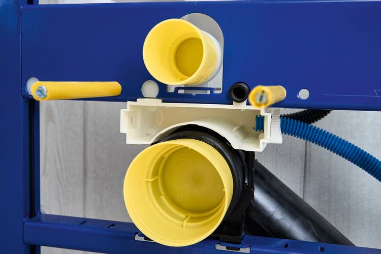 Detaillierte Nahaufnahme gelber und schwarzer Rohrleitungen mit Verschraubungen in moderner Gebäudetechnik, montiert auf blauem Metallrahmen.