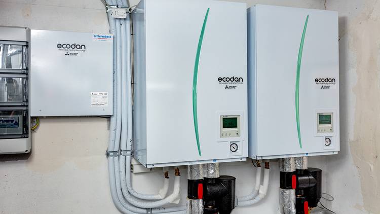 Weiße Verpackungsboxen mit grünen Designelementen, geeignet für den Einsatz von gebäudetechnischen Komponenten im SHK-Bereich.