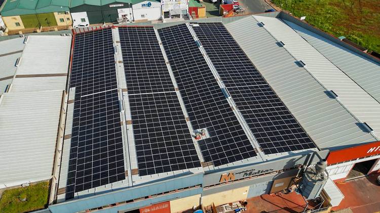 Luftaufnahme: Flachdach eines Industriegebäudes vollständig mit Photovoltaikanlage bedeckt - Beispiel für Energieeffizienz in der Gebäudetechnik.