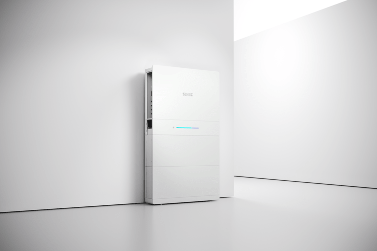 Wandmontierter, weißer Batteriespeicher für Energiemanagement in Gebäuden, installiert in modernem Technikraum mit heller, minimalistischer Gestaltung.