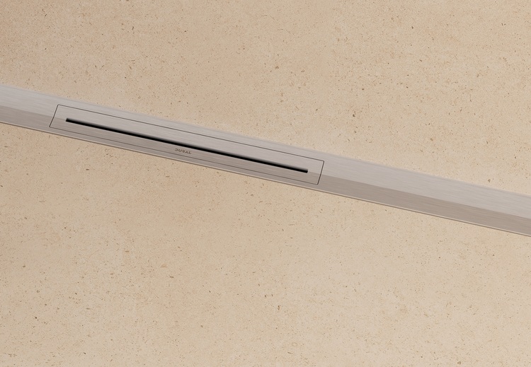 Schlanker, rechteckiger Bodenablauf in beige gefliestem Untergrund, geeignet für barrierefreie Sanitärbereiche in modernen Gebäuden.