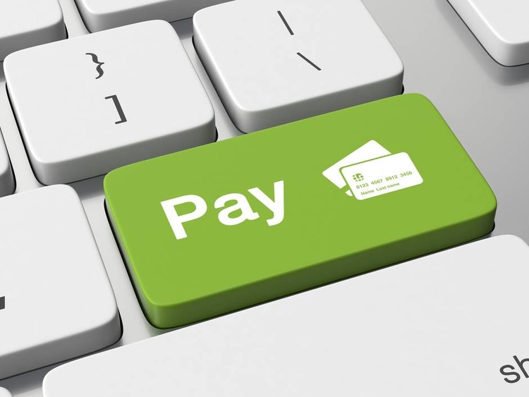 Grüne Computertaste mit der Aufschrift "Pay" und zwei Kreditkartensymbolen - Symbolbild für digitale Zahlungslösungen in der Gebäudetechnik-Branche.