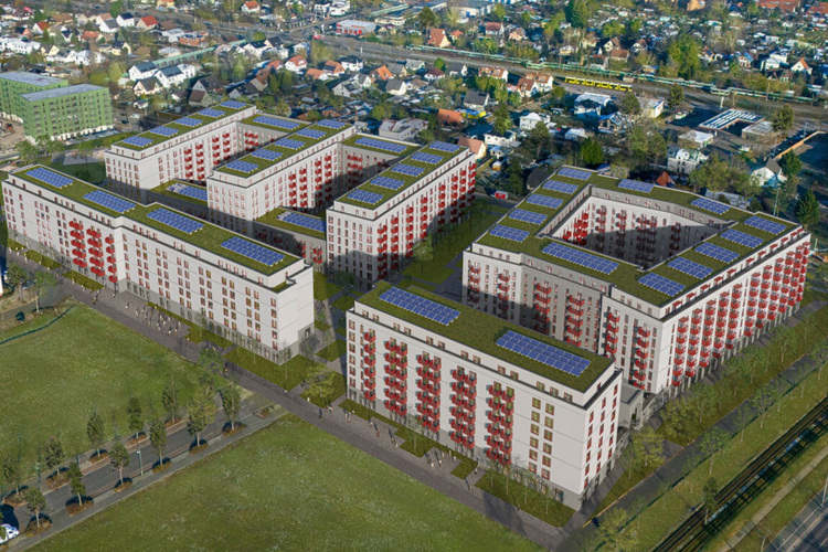 Luftaufnahme moderner Wohngebäude mit Photovoltaikanlagen und begrünten Dächern, Fokus auf nachhaltige Gebäudetechnik und Energieeffizienz im Quartier.