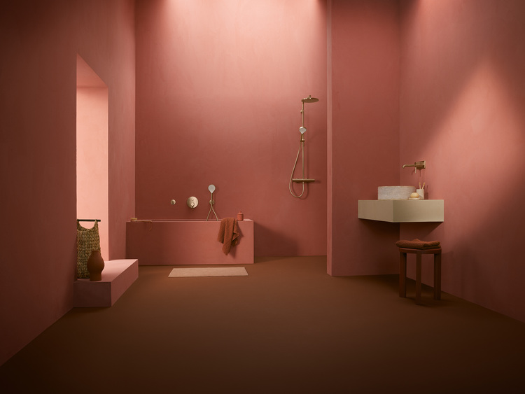 Barrierearmes Bad mit rosafarbenen Wänden, bodengleicher Dusche, Badewanne, Waschtisch und Hocker. Gut geeignet für moderne Gebäudetechniklösungen.