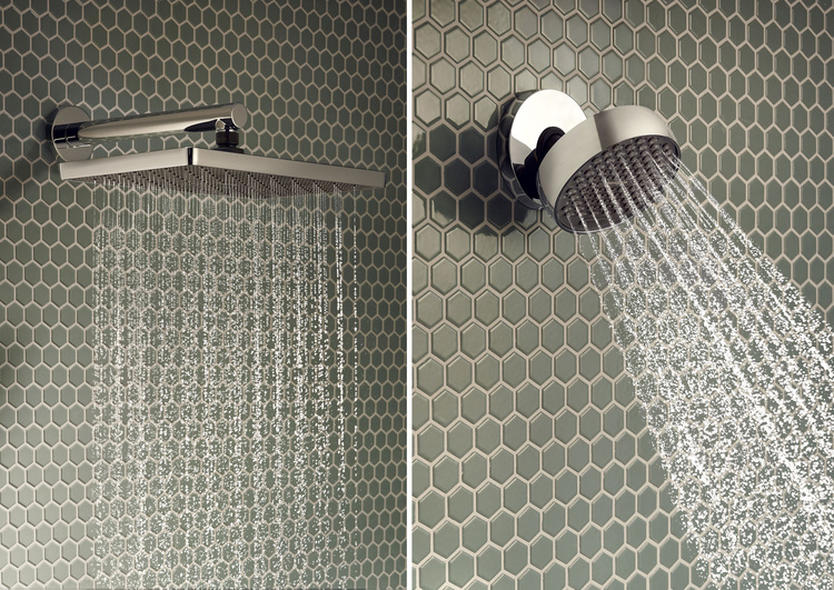 Zwei nebeneinander installierte Wandbrausen mit laufendem Wasser vor grünen Sechseckfliesen - Beispiel moderner Sanitärausstattung für Bäder.