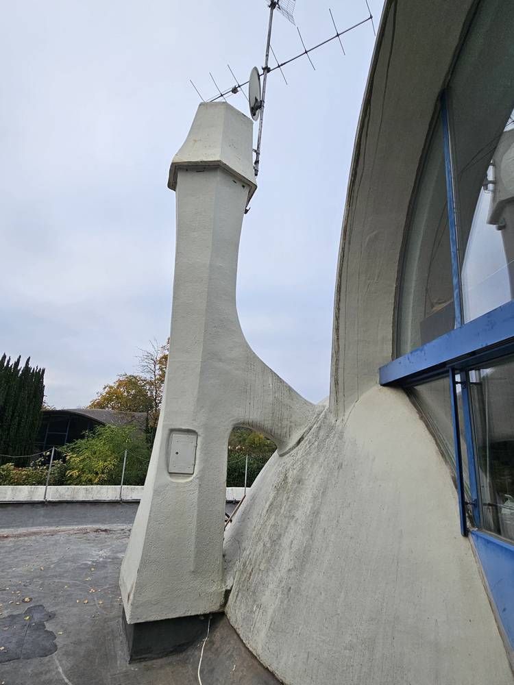 Moderne, gebäudetechnische Anlage mit Antenne und verglasten Segmenten auf einem Dach, geeignet für energiesparende Haustechniklösungen.