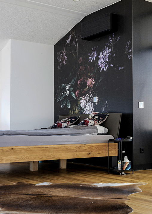 Schlafzimmer mit moderner Innenraumgestaltung: Holzfußboden, energieeffizientes Tageslicht und Gestaltungselemente für Wohnkomfort im Neubau.