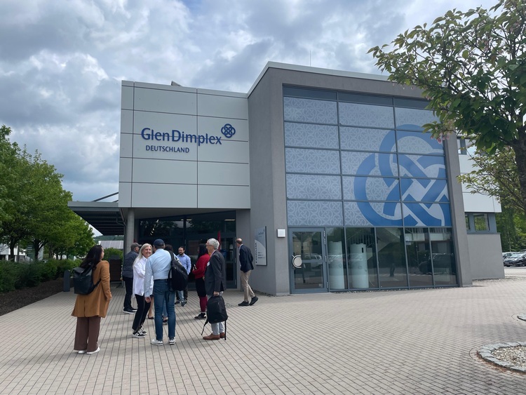 Entscheider und Fachbesucher besichtigen das Glen Dimplex Deutschland Firmengebäude bei Branchenevent für Gebäudetechnik an einem bewölkten Tag.