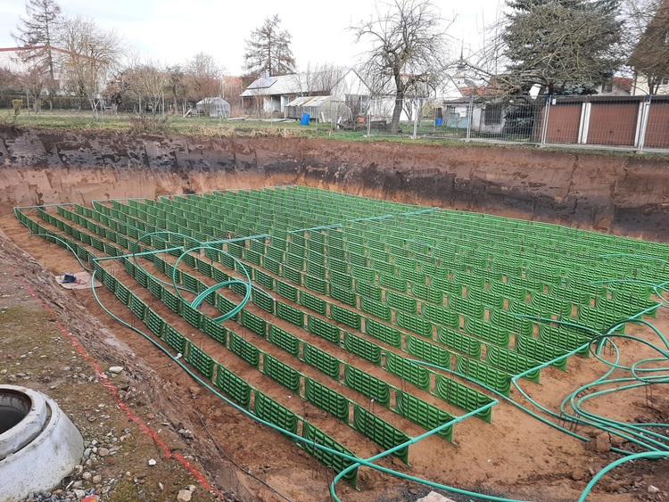 Bewehrungsstahl in grüner Beschichtung als Bewehrungsgitter für ein Gründungsfundament eines Gebäudes auf einer Baustelle, Fokus auf Korrosionsschutz.